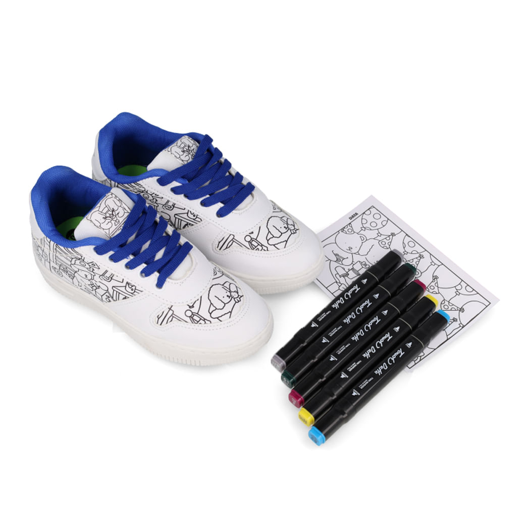 Tênis infantil branco com detalhes em azul royal e cadarço azul, acompanhado de canetas coloridas para personalização, visto de cima com fundo branco
